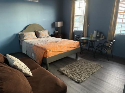 Branns HamletJJ Guest House的一间卧室配有一张床、一张桌子和一张沙发