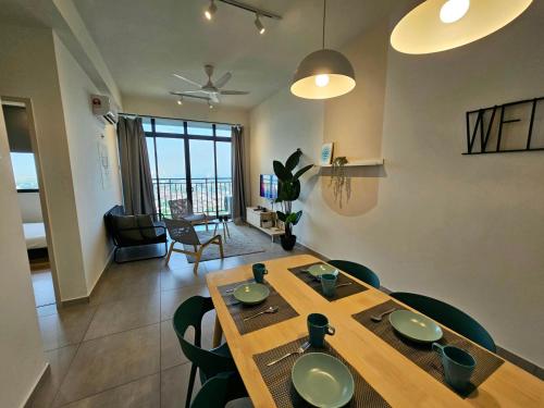 马六甲Quartz Paragon Suites By GGM的用餐室以及带桌椅的起居室。