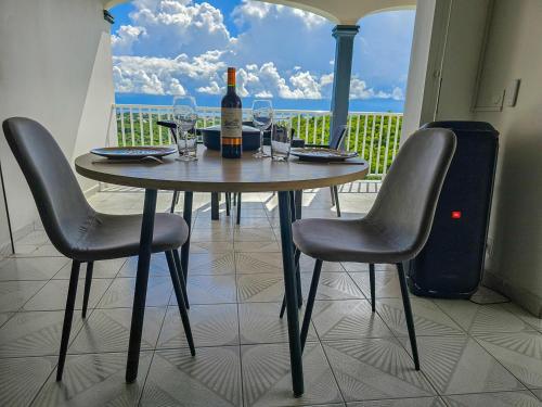 哥西尔Maison (Vu sur le Lagon)的一张桌子、一瓶葡萄酒和两把椅子