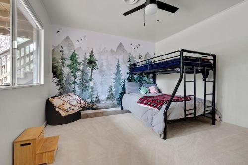 Twain HarteÁlaínn Cabin in the trees的卧室配有带木壁画的双层床。