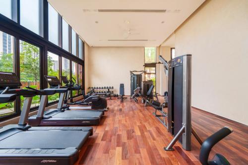 宝安梧桐酒店公寓宝安中心店的一间健身房,里面设有一排跑步机和椭圆机