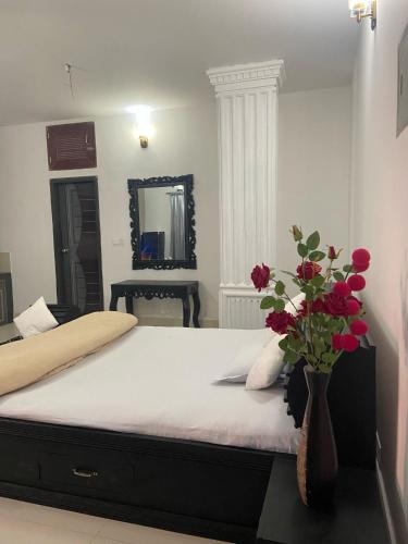 巴纳内拉斯Lovely studio flat的一间卧室,配有一张带红色花瓶的床