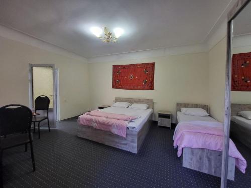 布哈拉Bobo Haydar Guest House的一间卧室配有两张床和镜子