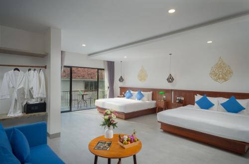 暹粒Angkor Aurora的酒店客房设有两张床和一张桌子。