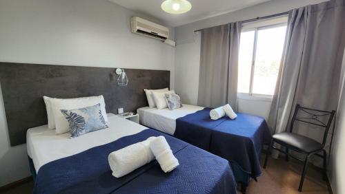 门多萨Essencial Hotel & Spa的酒店客房设有两张床和窗户。