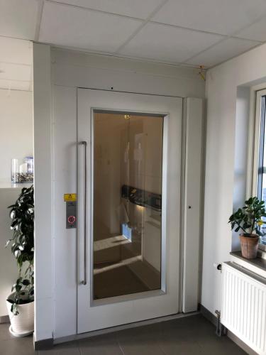 ÖckeröÖMC Kurshotell的玻璃门,在植物间