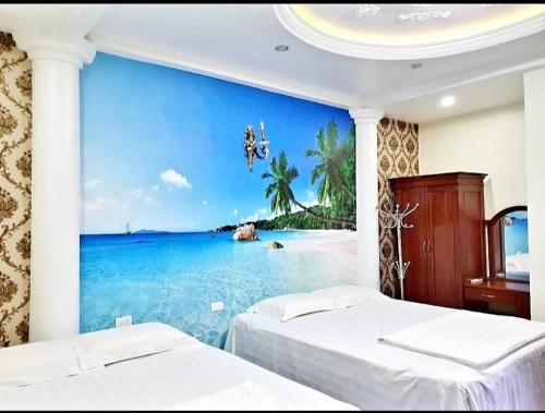 海防HAPPY GUEST HOUSE的一间卧室配有两张床,并拥有海滩壁画