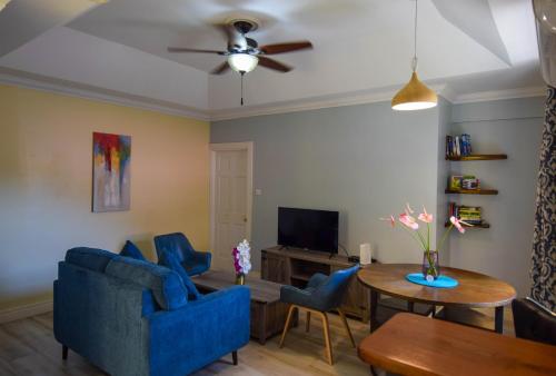 苏弗里耶尔Sea Piton View Apartment- Location, Convenience, Modern Living的客厅配有蓝色的椅子和桌子