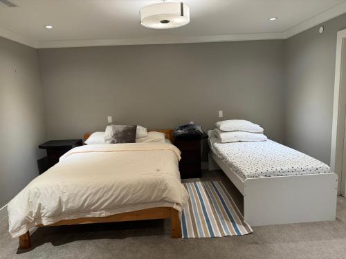 温哥华Charming Modern Home Near Downtown and UBC的一间带两张床的卧室和地毯