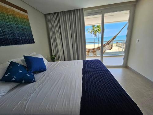 Barra do SirinhaémBeira mar com vista espetacular! Quinta da Barra!的一间卧室配有一张床,享有海滩美景