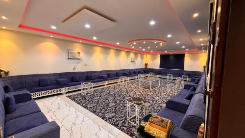 Al LaqīţahThenoblejewel的一间设有蓝色沙发和舞台的会议室
