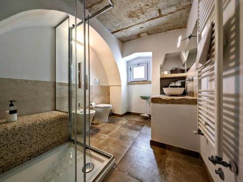 GiuggianelloOikia Vacanze Giuggianello Le Bey的一间带玻璃淋浴和卫生间的浴室