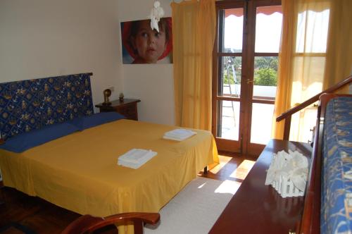 普拉Villa delle torri的一间卧室配有一张带黄色床单的床和一扇窗户。