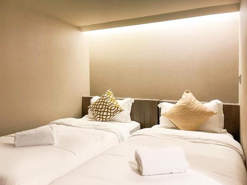 新加坡ST Signature Jalan Besar的配有2张床的带白色床单和枕头的客房