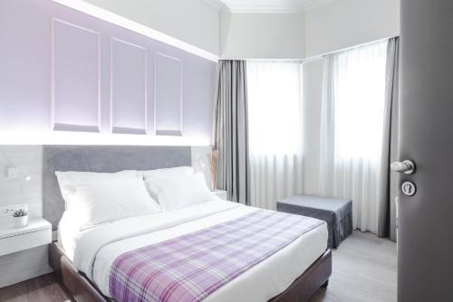 雅典雅典西普瑞亚酒店的白色的卧室设有床和窗户