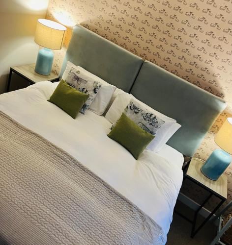 阿普尔克罗斯Clachan Manse Bed & Breakfast的一间卧室配有一张带绿色和白色枕头的大床
