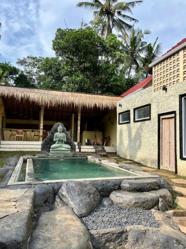 乌布BAMBOO OASIS的房屋前设有雕像的游泳池