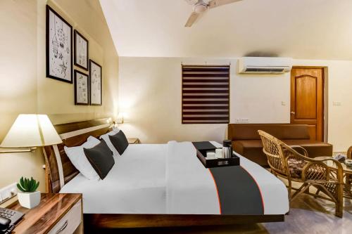 多纳保拉Collection O Hotel Sangia的配有一张床和一张书桌的酒店客房
