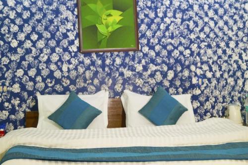 新德里Hotel HRS - New Delhi Railway Station的一间卧室配有两张带蓝白色枕头的床