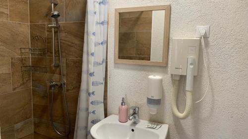 贾尔Toscan Panzió的浴室配有盥洗盆和带镜子的淋浴