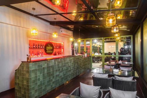 孟买Hotel Orritel West的餐厅设有酒吧,配有椅子和桌子