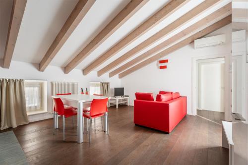 加尔达湖滨Villa Aranci Downtown的客厅配有桌子和红色椅子