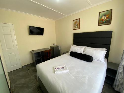 布拉瓦约Cumberland Guest Lodge的一间卧室配有一张白色的床和黑色床头板