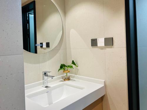 张家界Pikkie Designer's Stylish Three Bed Room Apartmemt的浴室设有白色水槽和镜子