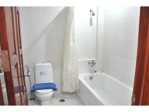 芭堤雅市中心海舞宾馆的白色的浴室设有卫生间和浴缸。
