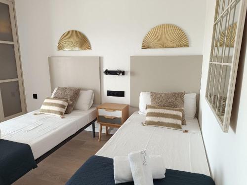 滨海阿雷尼斯Elegant apt 4 pax 1 min from the beach with Wifi的一间小房间,配有两张床和一张沙发