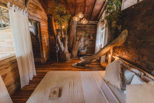 乌鲁瓦图Roots Tree House的小木屋内一间卧室,配有一张床
