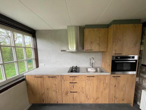 诺尔贝克Vakantiewoningen 'Hoeve de Witte Olifant'的一个带木制橱柜和水槽的厨房