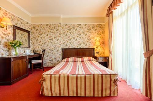 瓦尔纳锦绣精品酒店的配有一张床和一张书桌的酒店客房