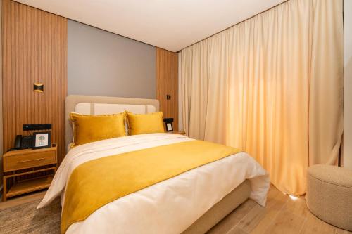马拉喀什Appart Hôtel Rambla的一间卧室配有一张带黄色枕头的大床