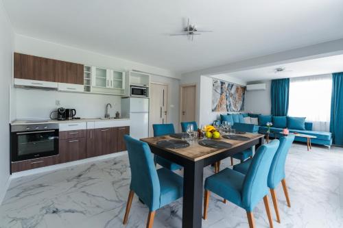 桑丹斯基ENEVI Guest Houses的厨房以及带桌子和蓝色椅子的用餐室。