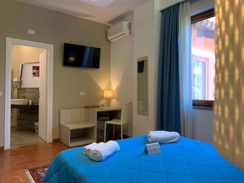 维博瓦伦蒂亚Villa Zufrò的一间卧室配有一张蓝色的床、一张桌子和一个窗户。