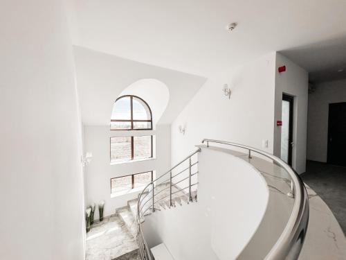 萨图马雷Complex Vila Rania的白色客房的螺旋楼梯,设有窗户