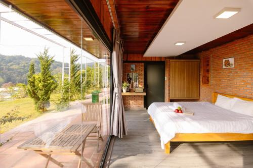 大叻Scent Bungalow - Village的一间卧室设有一张床和一个大窗户