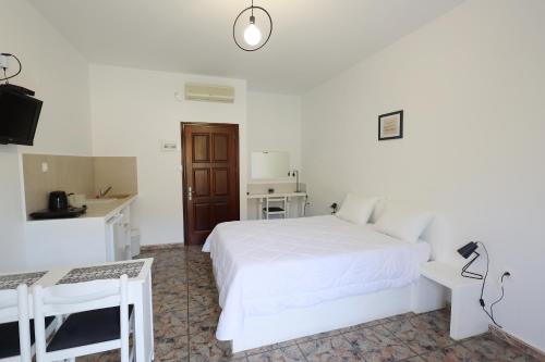 利普西岛Aphroditi Hotel的白色卧室配有白色的床和书桌