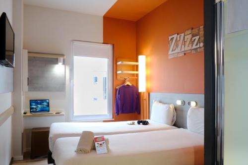 毕尔巴鄂Ibis Budget Bilbao City的酒店客房设有两张床和窗户。