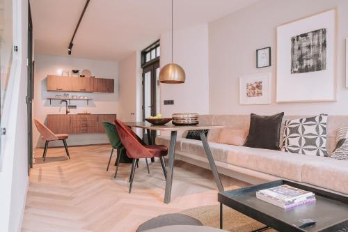 登博斯The Guest Apartments - Lange Putstraat的客厅配有沙发和桌子