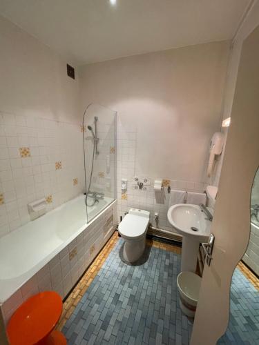 讷韦尔维尔顿酒店的浴室配有卫生间、浴缸和水槽。