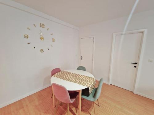布鲁塞尔Le cocon du midi - Appartement Cosy的一间带桌椅和时钟的用餐室