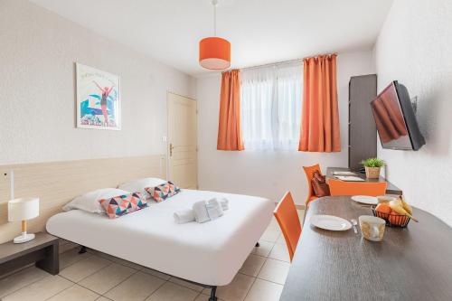 维特罗勒Appart'City Classic Marseille Aéroport - Vitrolles的卧室配有白色的床和桌子