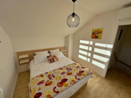 Gîte du Moulin- CLG Savoie - Vélo tourisme - 3CH - 2SDB的一间卧室配有一张床和吊灯