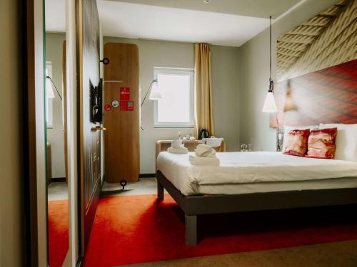 索非亚Ibis Sofia Airport Hotel的一间卧室配有一张大床,铺有红地毯
