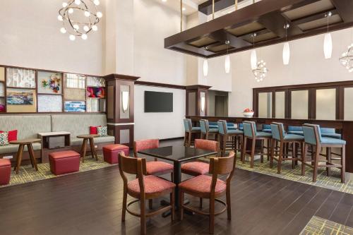 约克纽约南部汉普顿酒店及套房的餐厅设有酒吧,配有桌椅