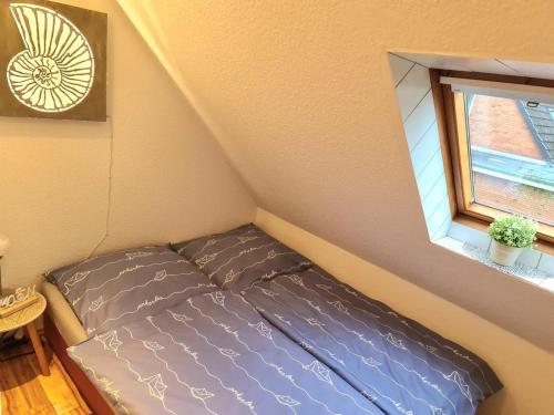 OesterdeichstrichFerienwohnung EINS nähe Büsum的一个小房间的一个床位,设有窗户