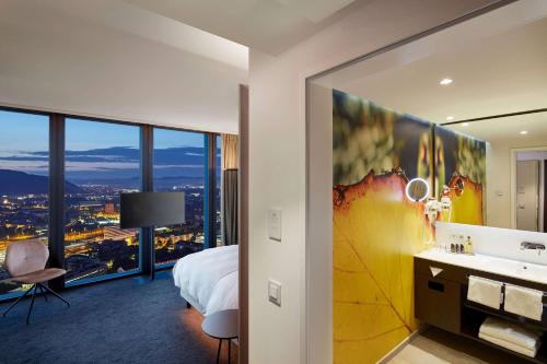 巴塞尔HYPERION Hotel Basel的酒店客房设有一张床和一间享有美景的浴室。