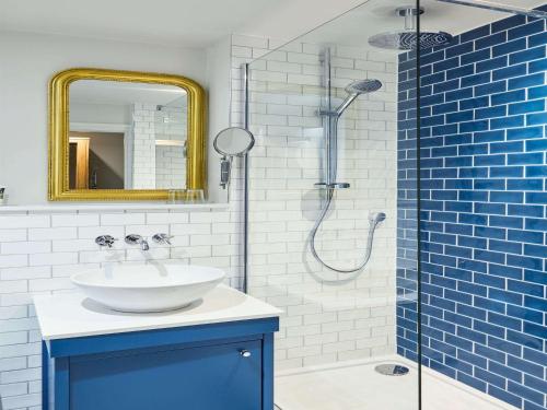 巴恩斯利Mercure Barnsley Tankersley Manor Hotel的蓝色和白色的浴室设有水槽和淋浴